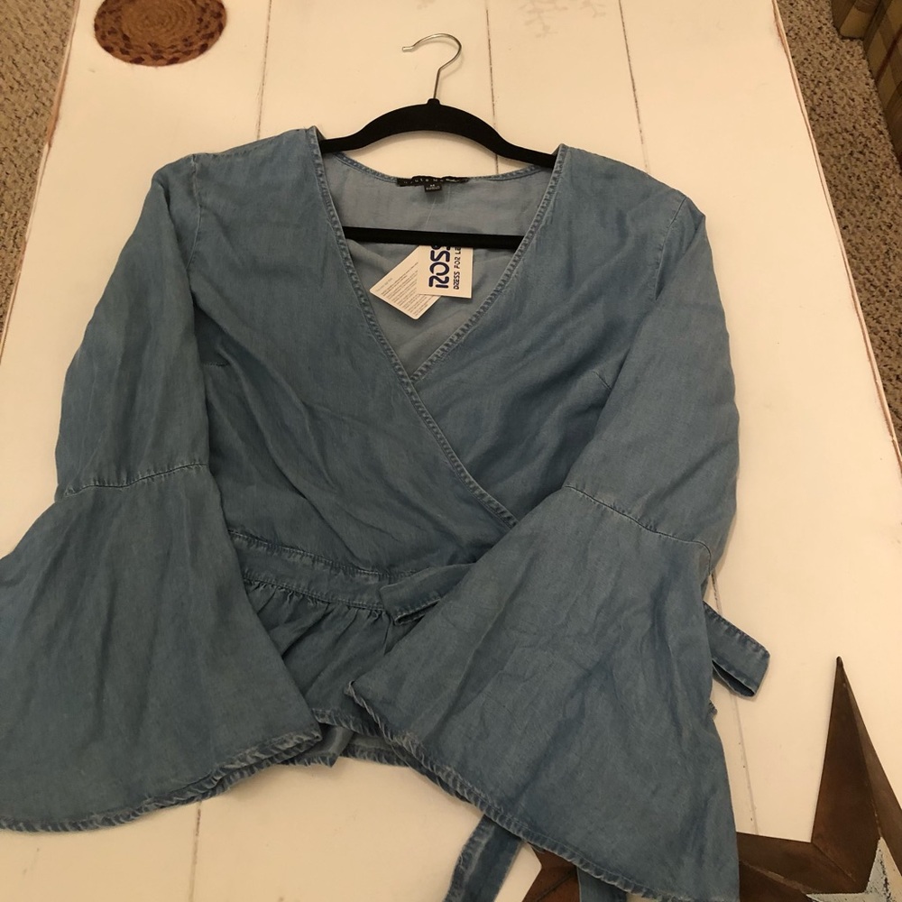 New with tags/light denim bell sleeve side wrap tie shirt with ruffled bottom.